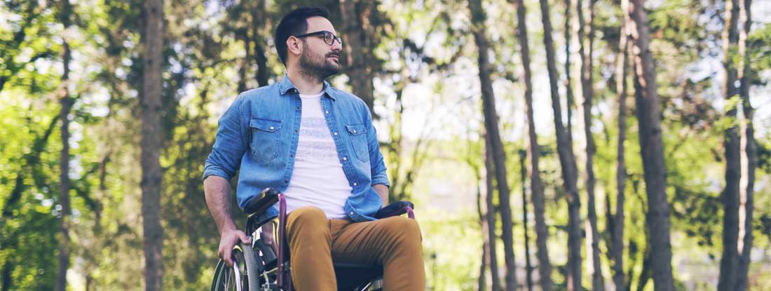 Man sitting in a manual wheelchair outdoors. Social security disability Insurance.