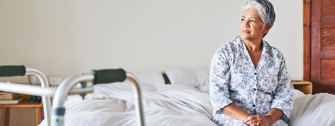 Woman looking outside through her window during the day. Long Term Care Insurance Tax Qualified vs Non-Qualified.