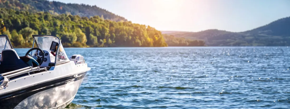 Fishing boat in the river during sunrise. Find South Dakota Boat Insurance.