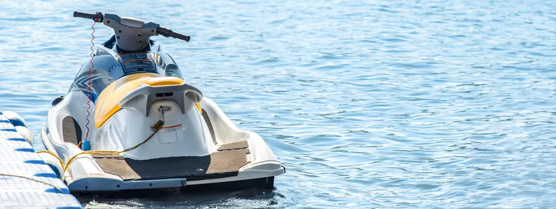 Jet ski moored a floating dock on serene waters. Find Jet Ski Insurance.