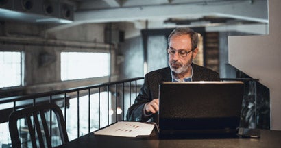 Man working on a laptop at a cafe. Future value of annuity.