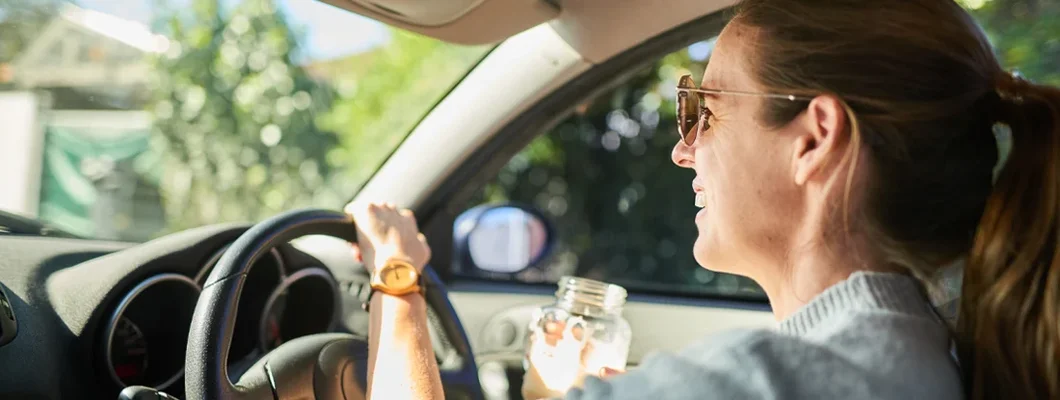 Smiling woman out for a drive in her car in the summer. How to Find the Best Car Insurance Policy in Whitefish Bay, Wisconsin.