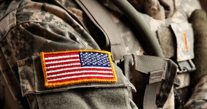 US Army Soldier in Universal Camouflage Uniform. Military and veteran car insurance discounts. 