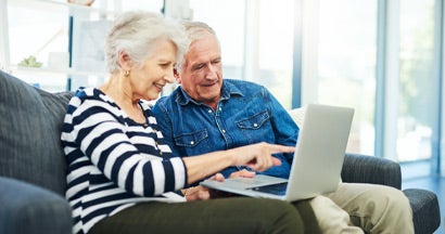 Couple using a laptop together on the sofa at home. Are variable annuities qualified?