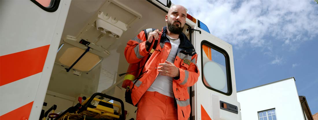 Paramedic getting out of ambulance. Find Paramedic Insurance.