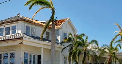 Damaged house roof after hurricane in Florida. How to calculate home replacement cost.