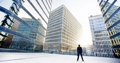 Businessman looking across the city financial district. Find premises liability insurance.