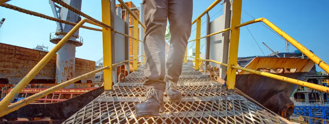 Engineer walking on the steel bridge cross over at workplace. Find Best Companies Workers' Compensation.