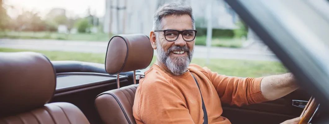 Man driving vintage car through the city. How to Find the Best Car Insurance at the Most Competitive Rate in Branson, Missouri.