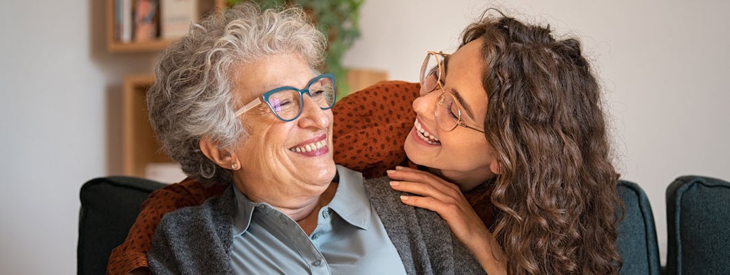 Grandmother and granddaughter laughing and embracing at home. Find Raleigh North Carolina life insurance. 