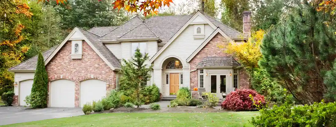 Suburban home in early Autumn as the leaves begin to turn. The Ultimate 7 Fall Home Maintenance Tips.