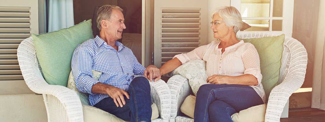 Elderly couple sitting together on a porch. Life insurance estate planning.