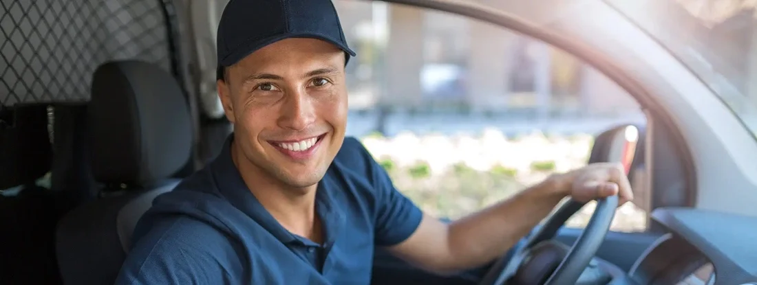 Delivery man sitting with boxes in his van. Find Texas Commercial Vehicle Insurance.