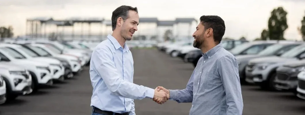 Salesman handshaking with a client after buying a car. How to Buy a Repo Car.