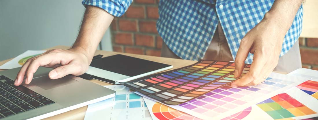 Graphic designer drawing on graphics tablet at workplace. Find graphic designer insurance.