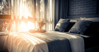 Bed maid-up with clean white pillows and bed sheets in room of bed and breakfast. 