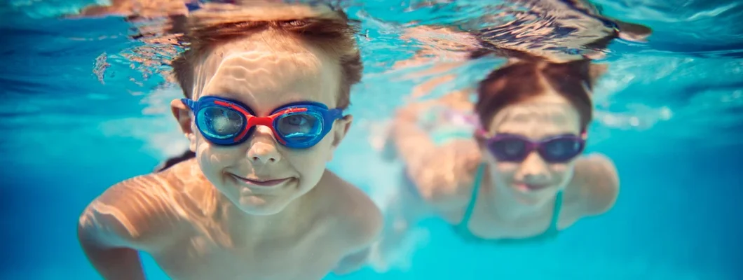 Kids swimming underwater in pool. 6 Fascinating Facts You Might Not Know About Pool Liability.
