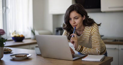 Woman using a laptop while working from home. Is a Car-Buying Service Right For You? 