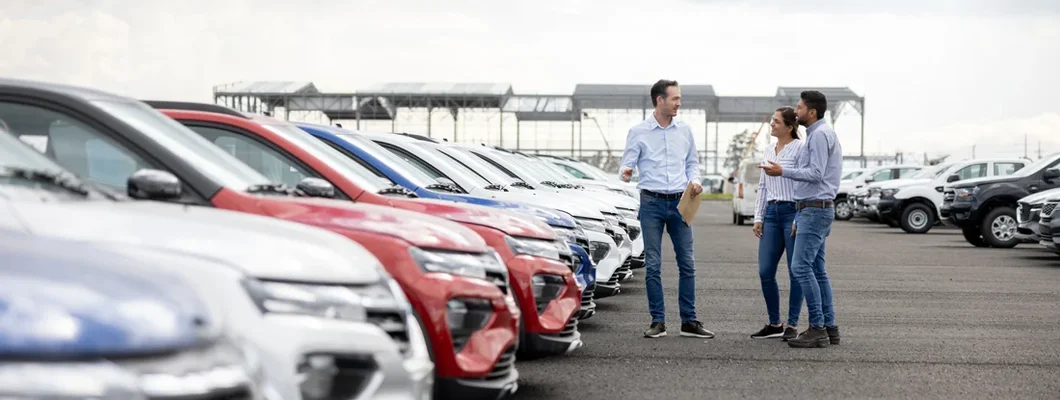 Salesman showing cars to a couple at the dealership. How to Calculate Car Depreciation.