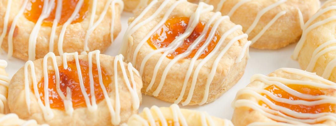 Close up of homemade cream cheese Kolache cookies filled with apricot and glazed. Find South Dakota Restaurant Insurance.
