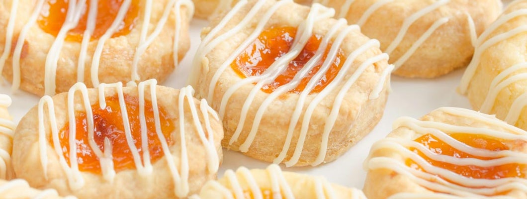 Close up of homemade cream cheese Kolache cookies filled with apricot and glazed