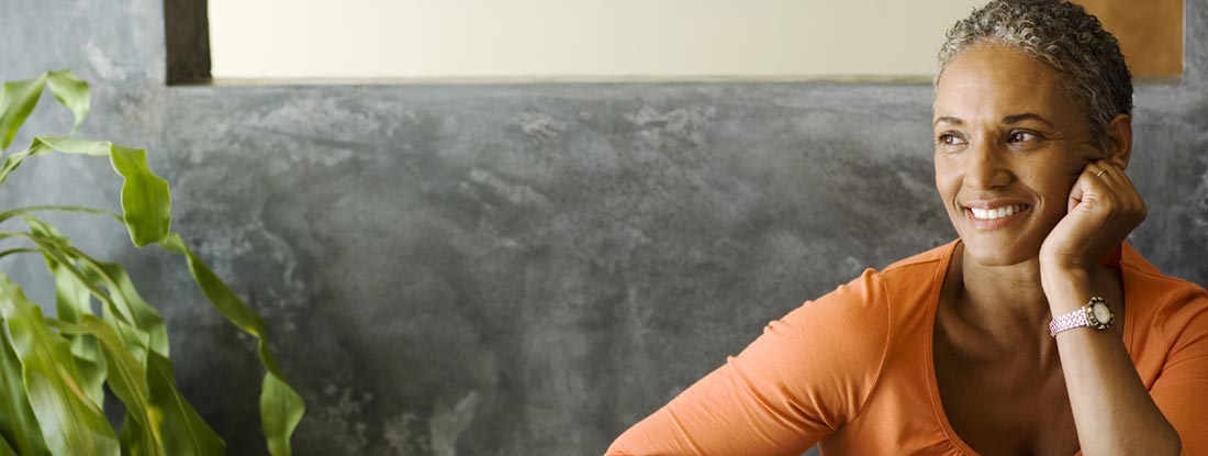 Woman sitting at a table smiling. How does a variable annuity work?