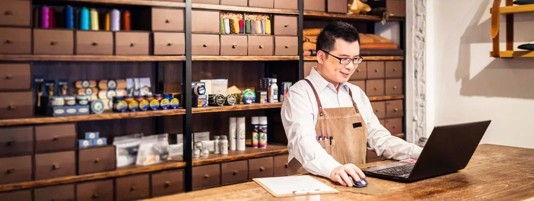 Small business owner filling orders on computer. Find Great Neck, New York business insurance.