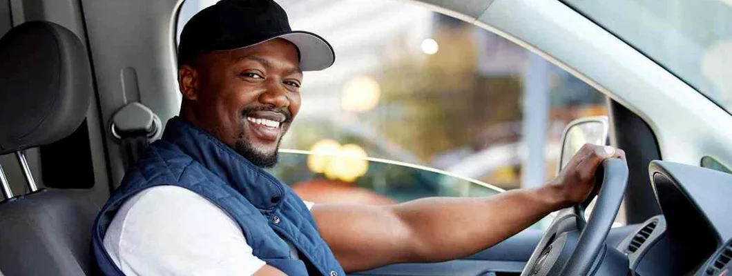 Man delivering a package while sitting in a vehicle. Iowa Commercial Vehicle Insurance.