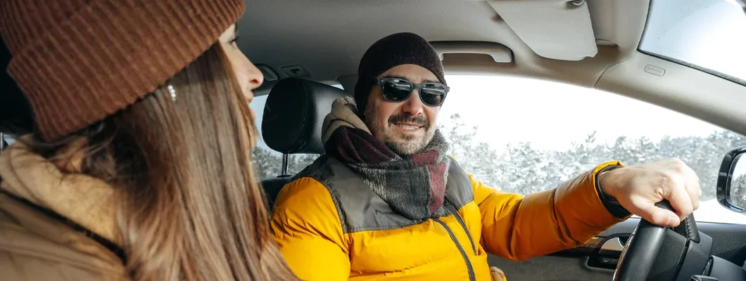 Couple sitting in car in winter coats in winter. How to Find the Best Car Insurance Coverage in West Point, UT.