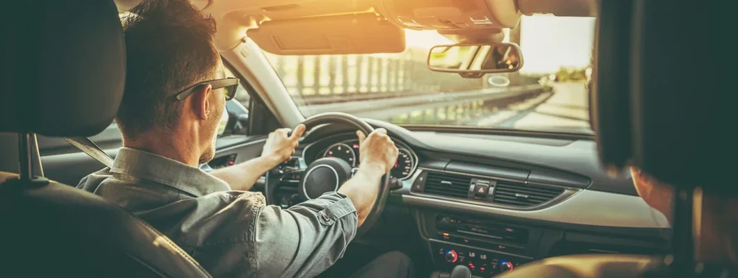 Couple on the Road Trip in Car with Large Sunroof. How to Find the Best Car Insurance in Sheridan, WY. 