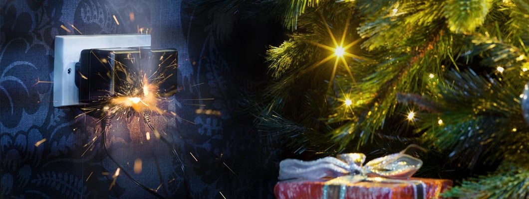 Christmas lights plugged in at night with sparks from outlet. Holiday Decoration Hazards.