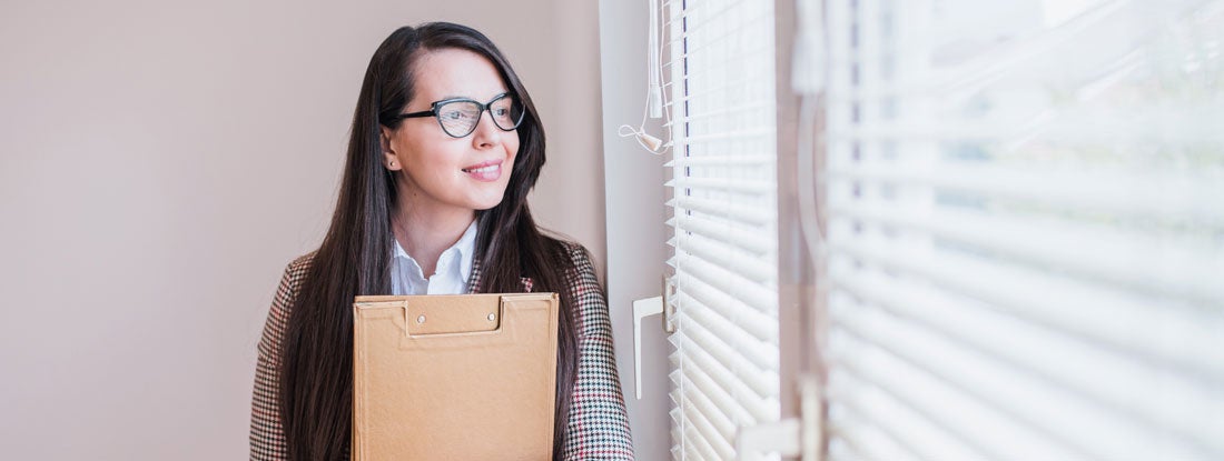 Landlord looking out office window. Find Indiana Landlord Insurance.