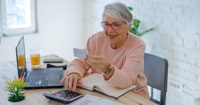 Woman online using laptop with insurance card. Car Insurance Policy Number. 