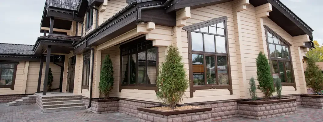 Decorative trees growing outdoors between windows of luxurious house. How to Find the Best Homeowners Insurance in Stone Ridge, Virginia.