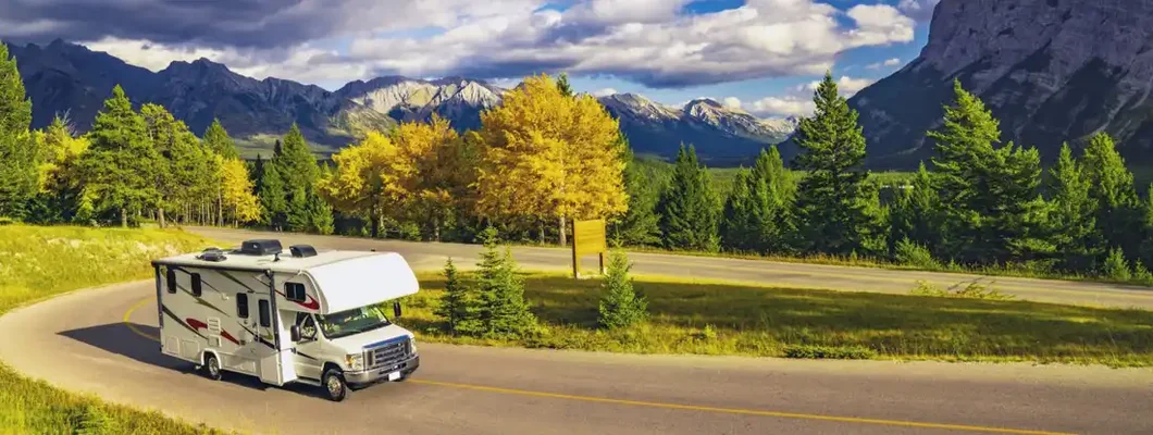 Recreational Vehicle Driving on Autumn Highway In Beautiful Mountains Wilderness. Get RV Insurance Quotes.