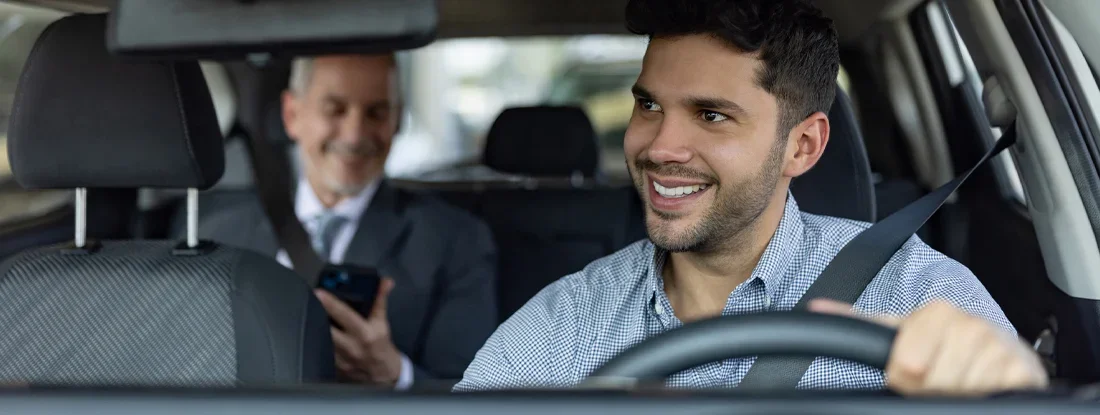 Rideshare driver talking to a passenger in the back seat. The Best Rideshare Insurance. 