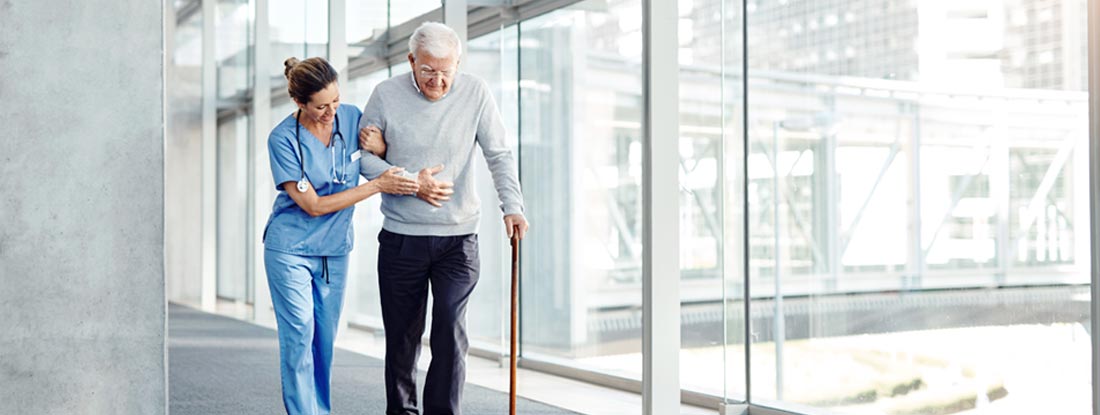 Female nurse assisting her senior patient while walking. Hybrid long term care insurance companies.