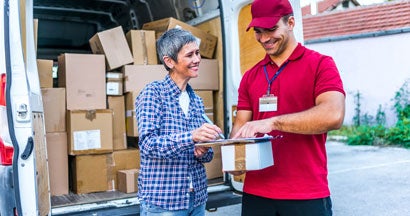 Woman signing for her delivery from the courier. Find Alabama Commercial Vehicle Insurance.