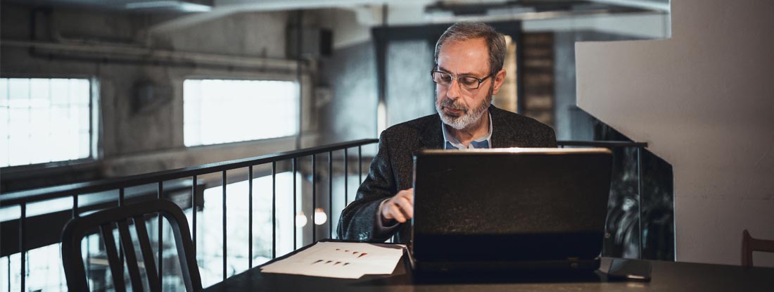 Man working on a laptop at a cafe. Future value of annuity.