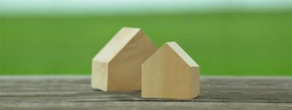 Two wooden house-shaped blocks sitting on a table.