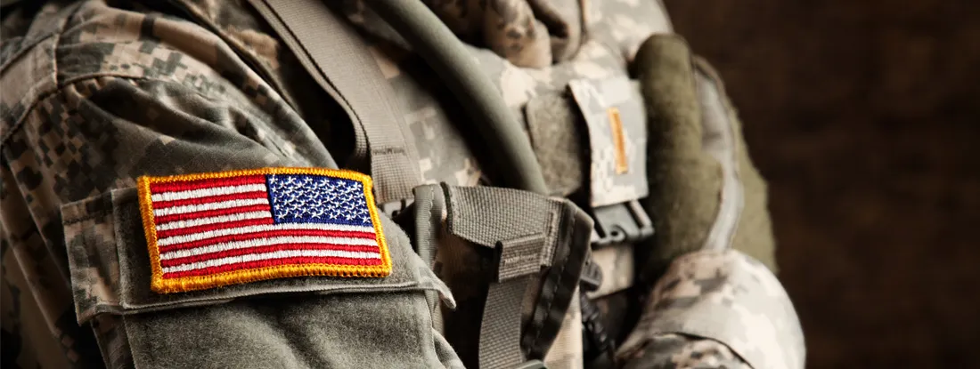 US Army Soldier in Universal Camouflage Uniform. Military and veteran car insurance discounts.