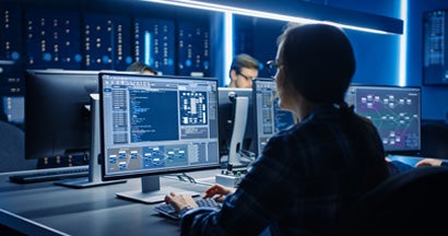 IT Programer Working on Desktop Computer in Data Center System Control Room. Find cyber liability insurance.