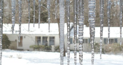 Icicles hang from the eaves on a cold winter morning. Ice Dams in Illinois: Insurance Coverage and Top Prevention Tips.