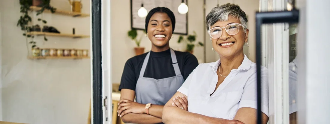 Coffee shop, senior woman manager portrait with barista feeling happy about shop success. How Much Does Small Business Insurance Cost in 2025?