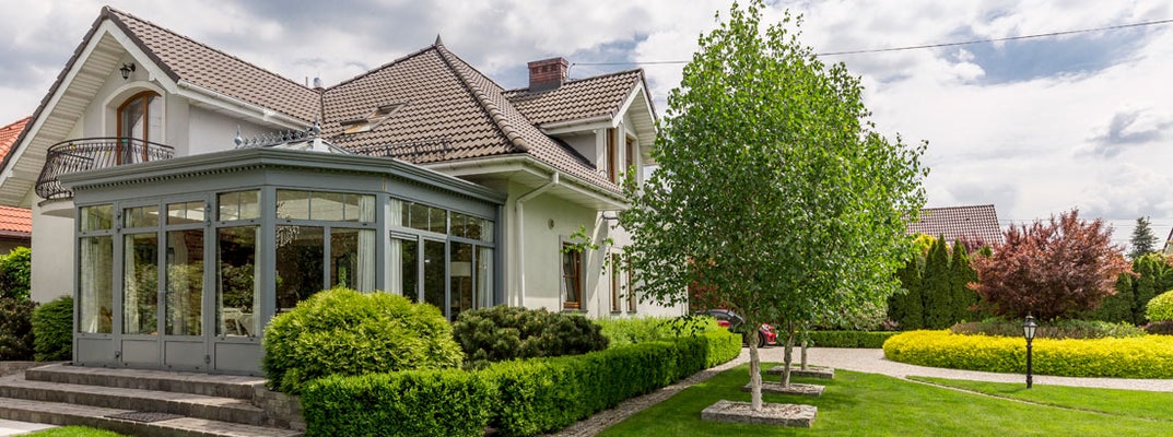 Single family house surrounded by garden and lawn. Find Rogers Arkansas home insurance.