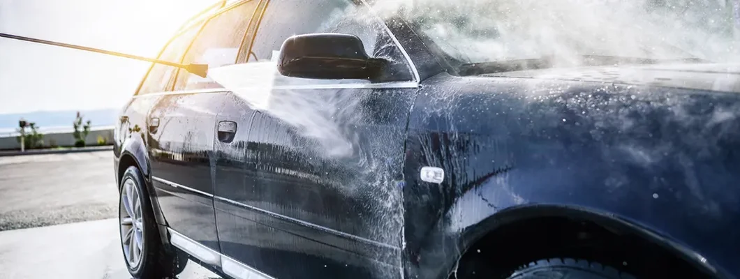 High-pressure washing car outdoors. Find the Best Car Insurance in Long Grove, Illinois at an Affordable Rate.