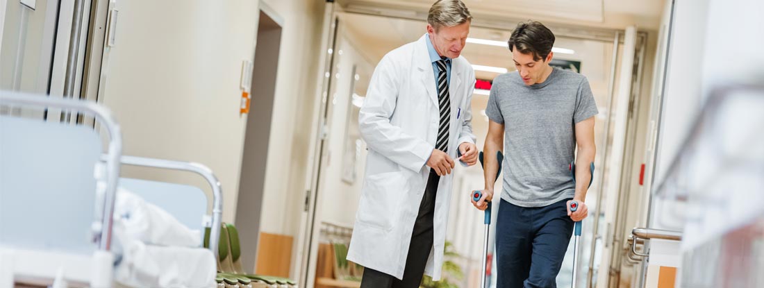 Man with broken leg talking with doctor in hospital corridor. How long does voluntary short term disability last.