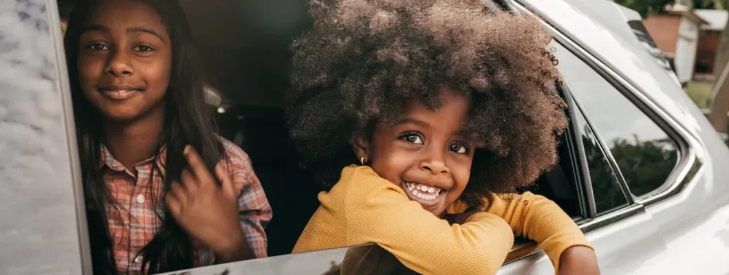 Smiling kids in car. How to Find the Best Car Insurance Coverage in Garden City, NY. 