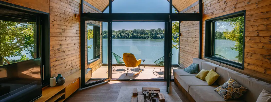 A scenic view from inside of weekend cottage by the riverside. How to Insure a Vacation Home.