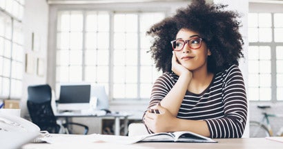 Cheerful young entrepreneur sitting on desk